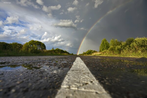 Asphalte humide et arc-en-ciel après la pluie