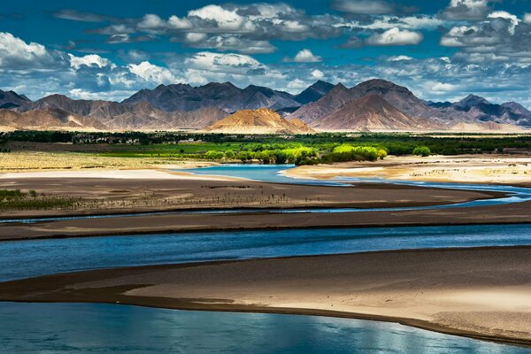 Un oasis a la sombra con montañas en el horizonte