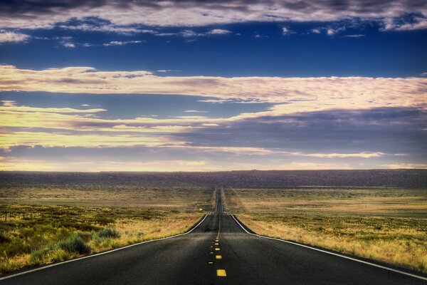 A long road with a beautiful landscape