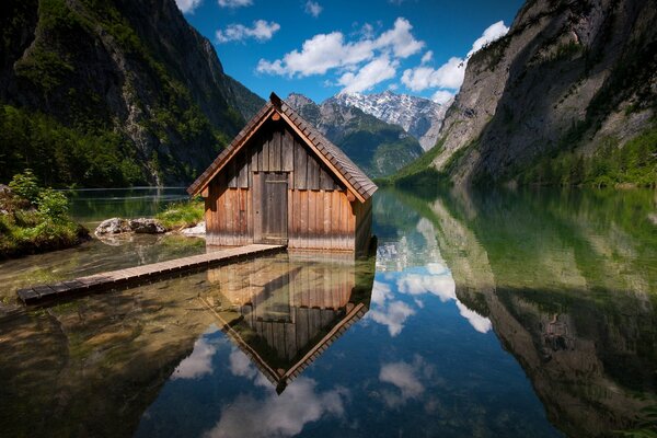 A house by the lake with a bridge in the mountains