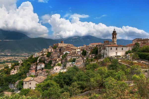 Un castillo en una montaña en medio de casas en Italia