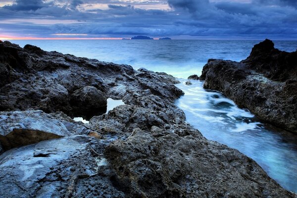 Mountains and sea under a cloudy sky