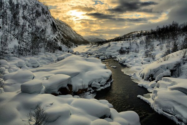 Der Fluss fließt durch Berge und Schnee