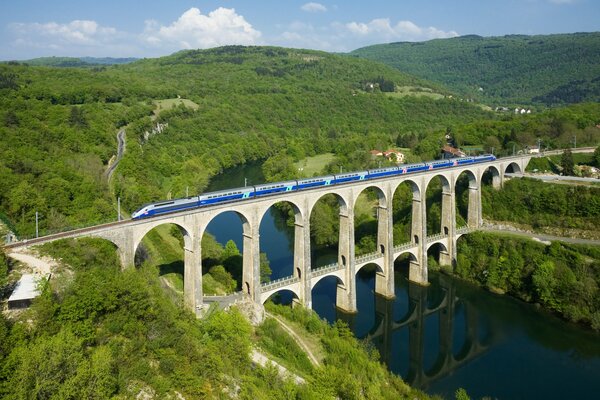 Un train bleu se précipitant sur un pont français