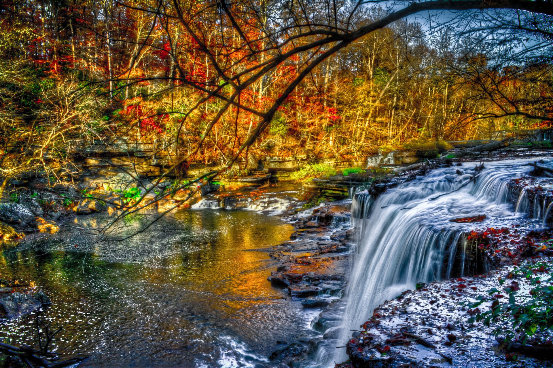 fluss überrollen steine wasserfall wald bäume gelb-rot-grün laub herbst