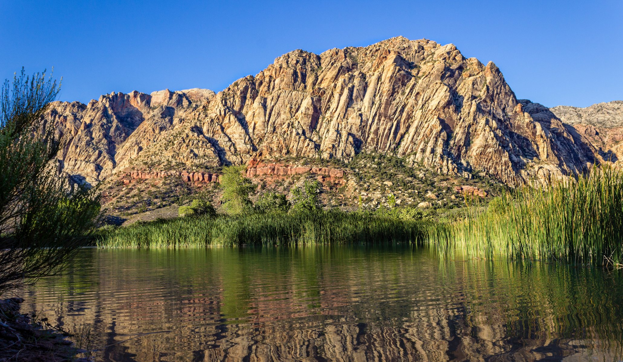 lake beach grass mountain slopes sky reflection