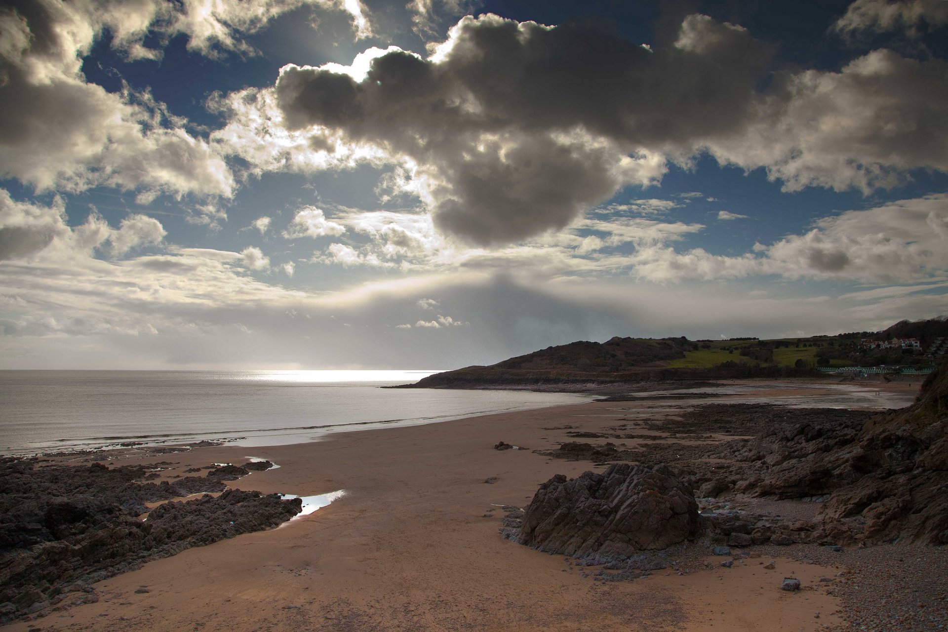 mar playa piedras arena nubes