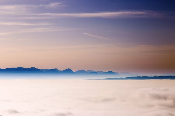 Thick fog and the tops of the Alpine mountains