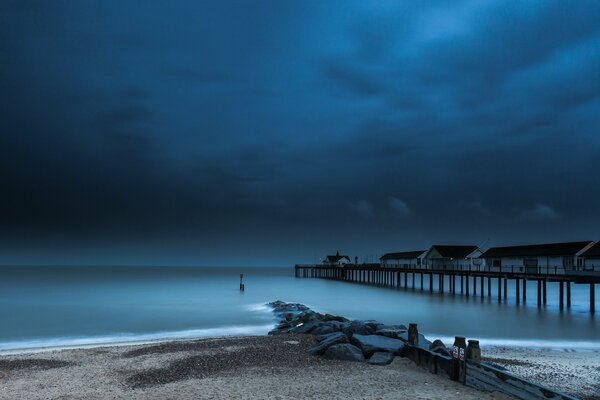 Muelle crepuscular en el fondo de los as oscuros