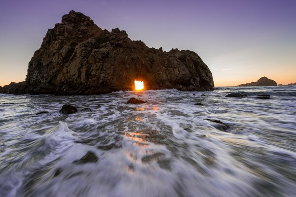 Rocher dans la mer et le coucher de soleil mousseux