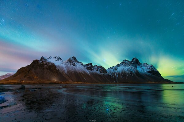 En las montañas, la Aurora boreal en el cielo nocturno