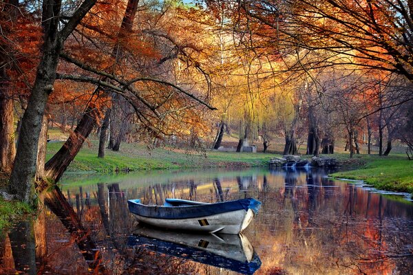 A forgotten boat in an autumn pond