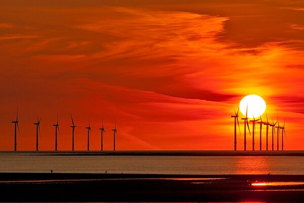 Molinos de viento y el sol que se pone detrás de ellos