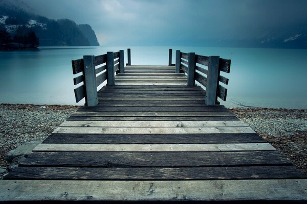 Depression, graue Landschaft und Pier über dem See