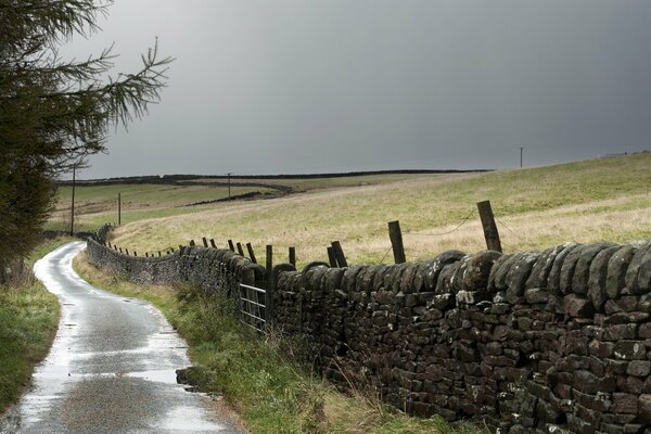 Landscape- a road next to a fenced field