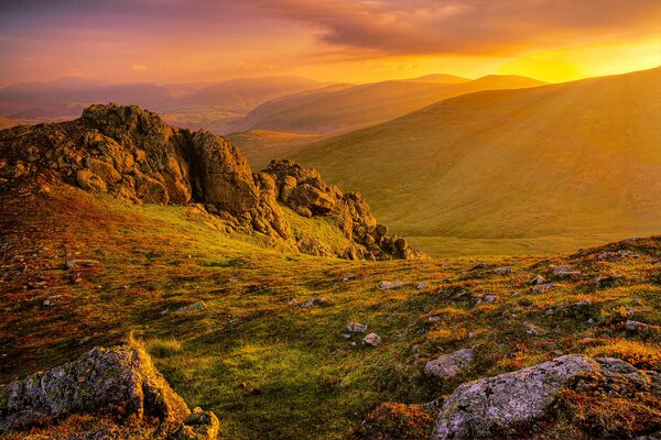 Pierres et collines de montagne éclairées par les rayons du soleil sortant