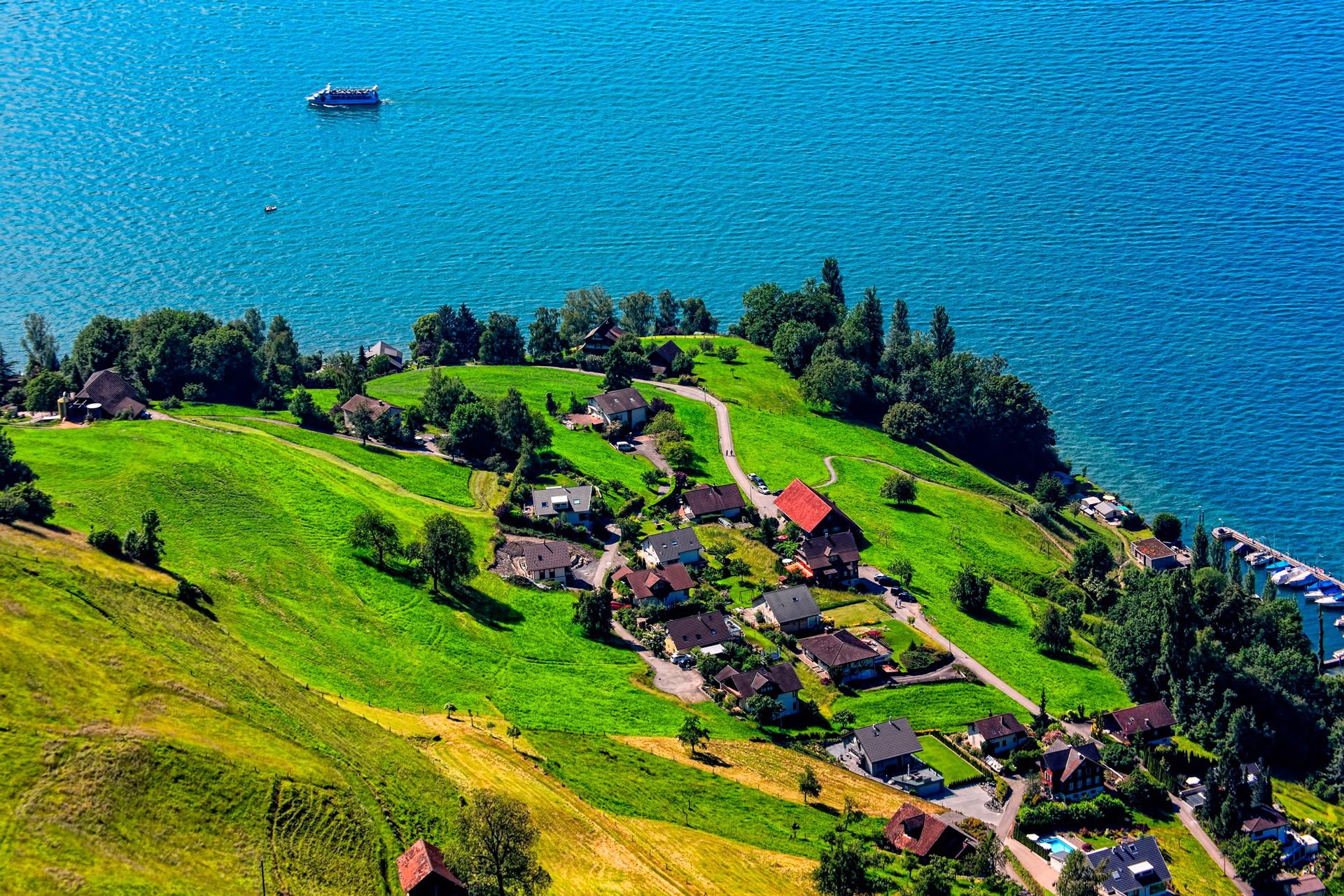 lago barco colina montaña hierba árboles casas