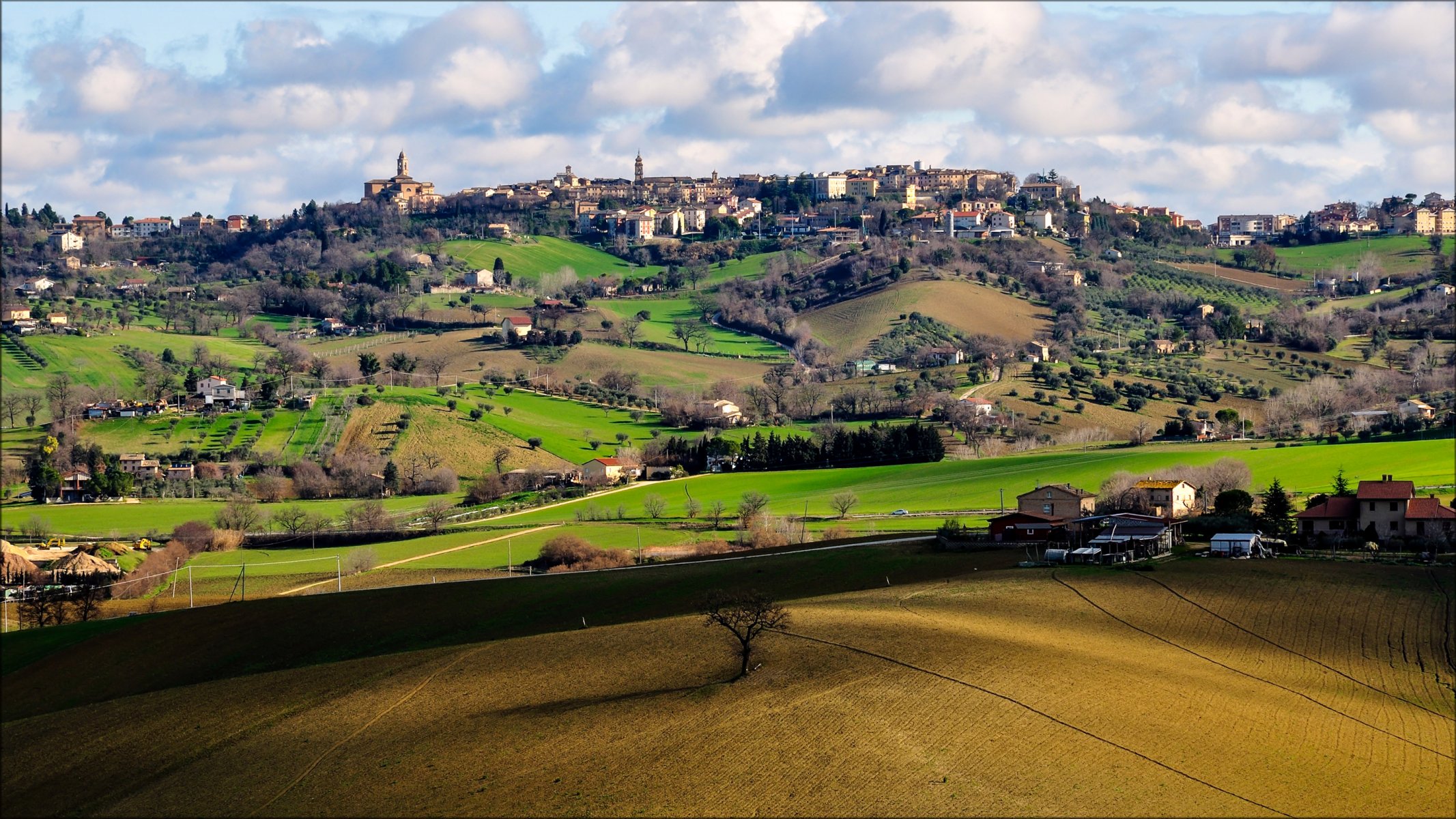 pollença macerata italy sky clouds town house hills of the field tree gra