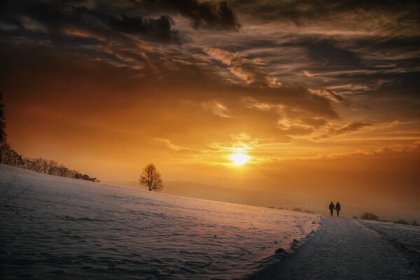 Persone che camminano sullo sfondo del tramonto