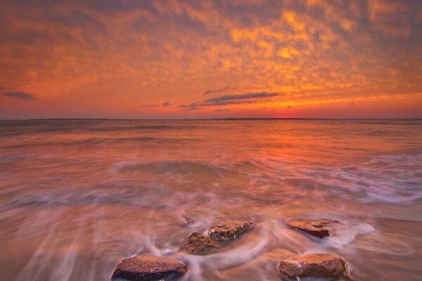 Bright sunset on the sea with rocks