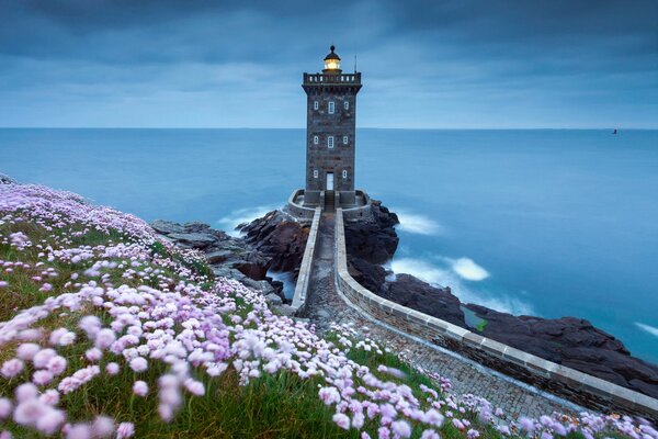 A lighthouse burning in the twilight of the sea