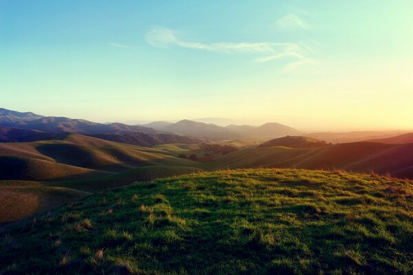 Collines herbeuses avec le soleil couchant