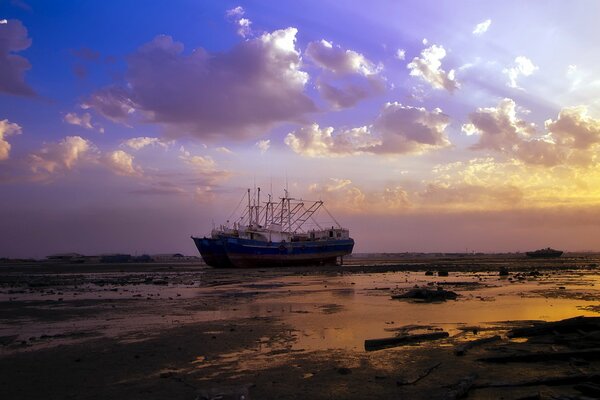 Das Schiff ist in den Wolken des Sonnenuntergangs pleite