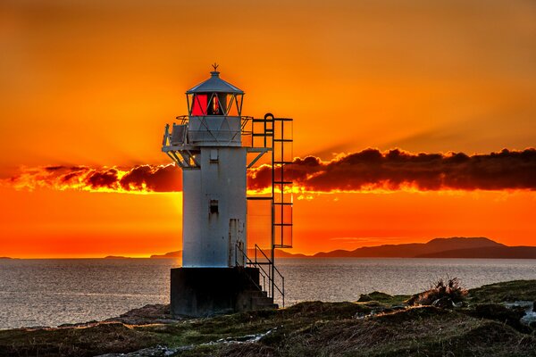 A white lighthouse on an orange sky background