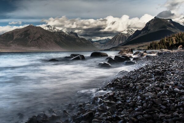 Mountain lake with black stones on the shore