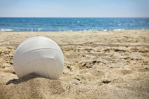 Weißer Volleyballball im Sand