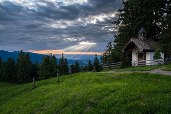 Eine kleine Kapelle in den Bergen mit Wald