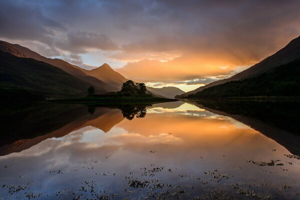 Autumn sunset in Scotland. The sky reflected in the water and the mountains