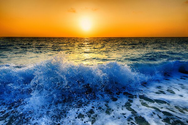 Coucher de soleil ensoleillé. Vagues avec des éclaboussures