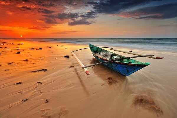 Barco solitario en la playa de arena por la noche