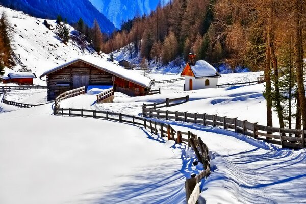 Winterberge mit Wald, mit Schnee bedeckt . Im Tiefland gibt es Häuser mit einem straßenumzäunten Zaun