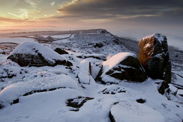 Sunset in the area of a snow-covered stone plateau