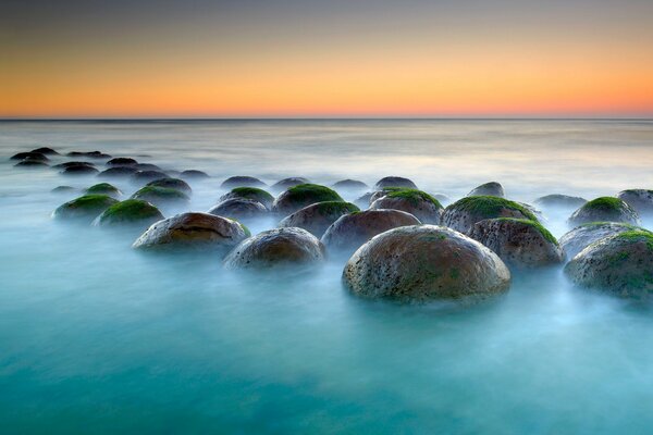 Rocas en forma de bola con algas en el mar