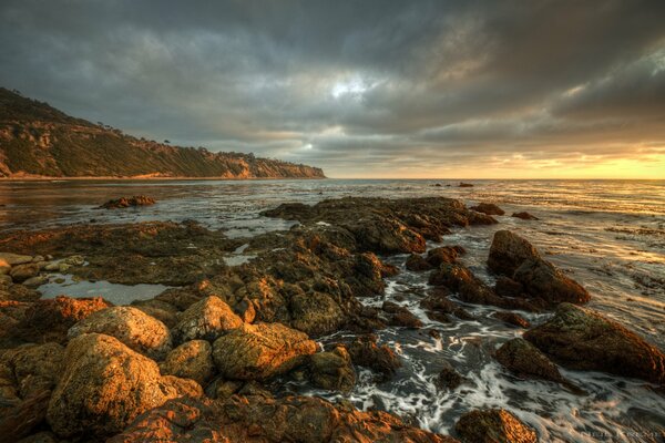 The rocky shore looks beautiful at sunset