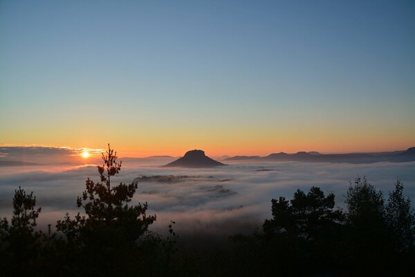 Montagne dans le brouillard, ciel coucher de soleil