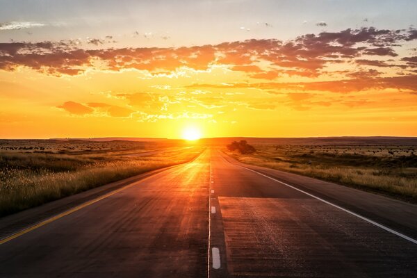 Puesta de sol sobre la carretera. campo. nubes de oro