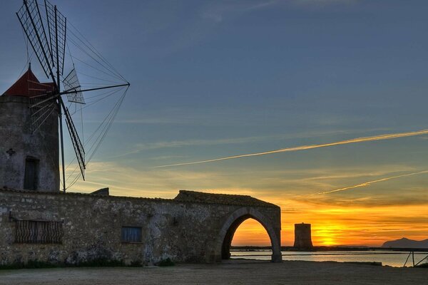 Windmühle auf Auftrag und Wasser Hintergrund. Italien