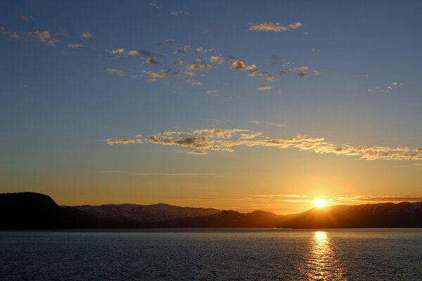 Tramonto in mare. montagne all orizzonte