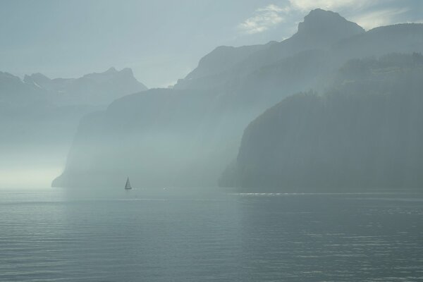 Nebliger Morgen eines Segelbootes am See