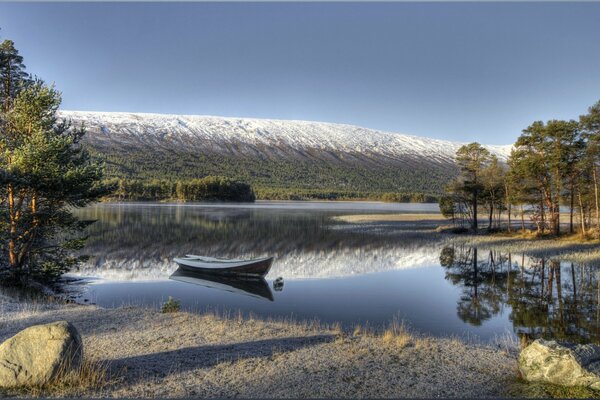 Paisaje invernal de Noruega con un barco en la costa