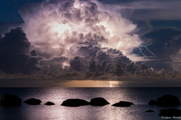 Nubes nocturnas con relámpagos sobre el mar