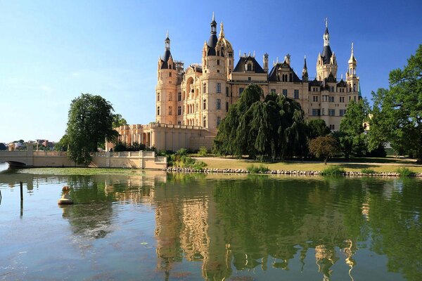 Grand château au bord du lac avec des arbres