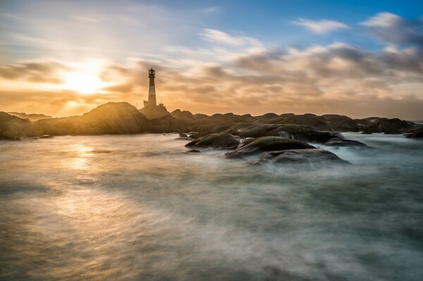 Faro en las rocas en la niebla Dalí