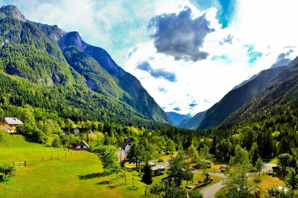 Pente verte avec des maisons dans les montagnes