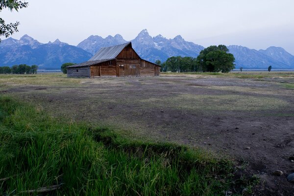 A house in a field against the background of mountains