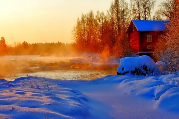 Vapeur sur la rivière et la neige sur fond de coucher de soleil